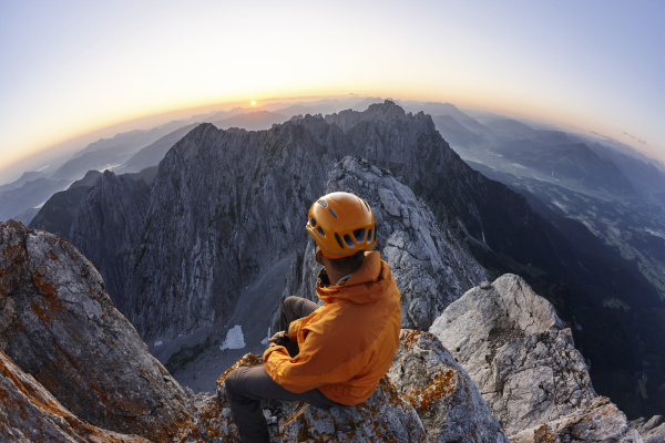 climber with orange helmet sitting on