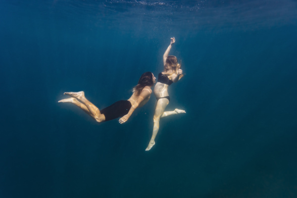 young couple under water woman