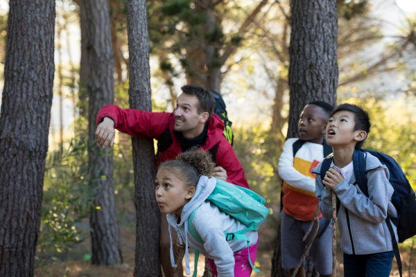 teacher pointing at distant in forest