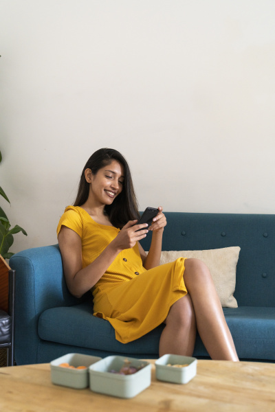 smiling young woman sitting on couch