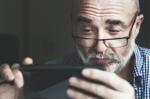 senior man using smartphone at home