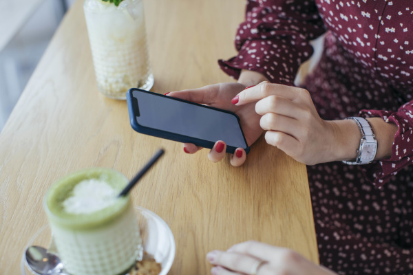woman holding smartphone in a cafe