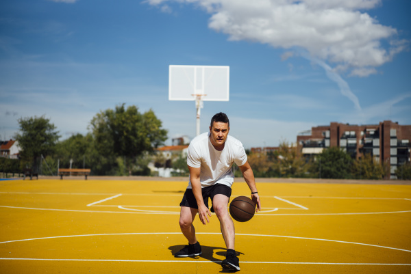 man playing basketball on yellow court