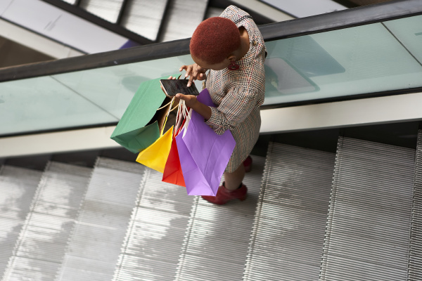 young woman holding colorful shopping bags