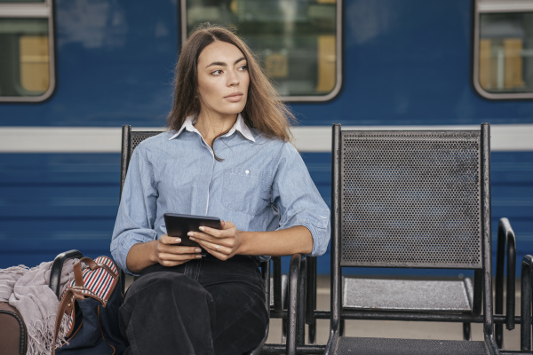 young female traveller waiting on station