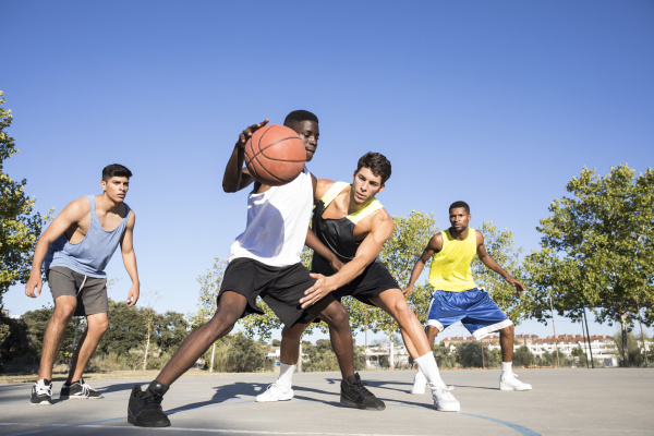 young men playing basketball and dribbling