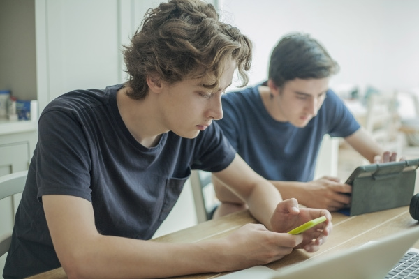 two teenage boys using smartphone and