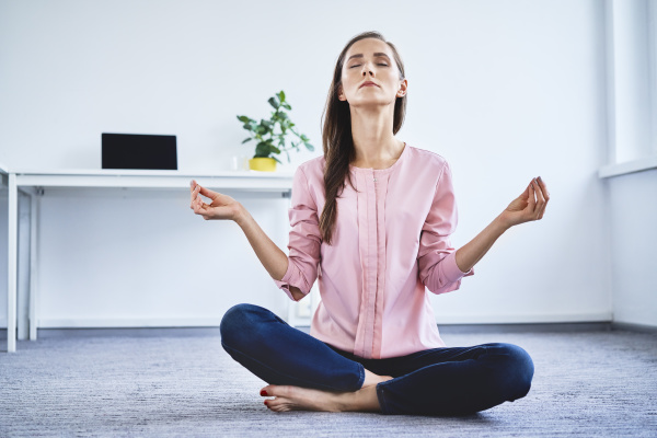 young woman meditating on floor in