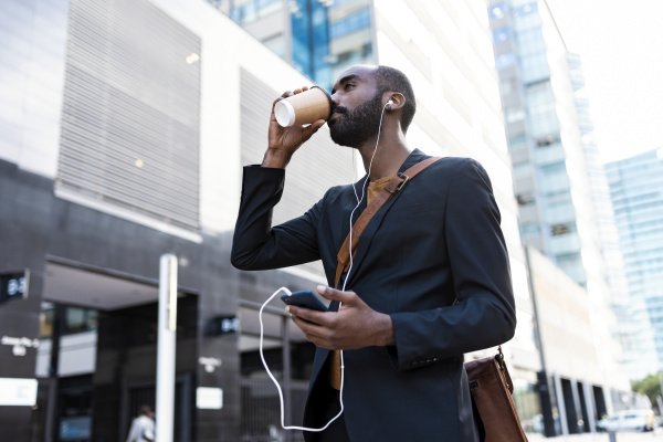 young businessman with earphones and smartphone