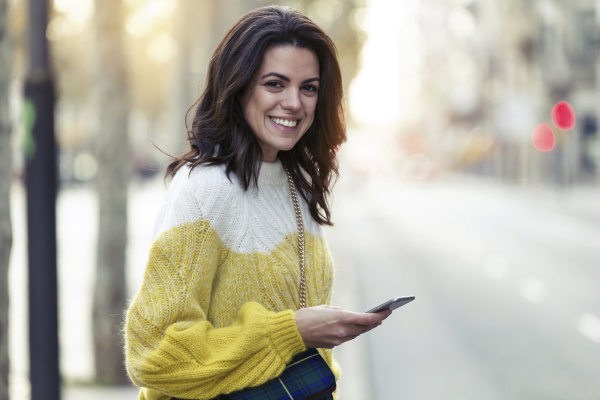 happy woman holding her smartphone in