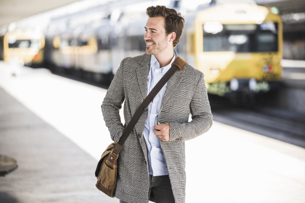 smiling young businessman at the train