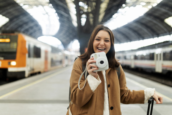 happy young woman with camera at