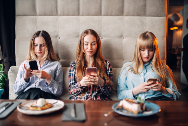 three girls using mobile phones in