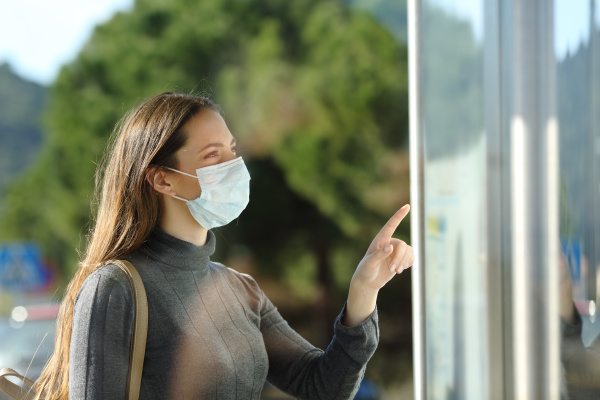 woman wearing a mask checking schedule