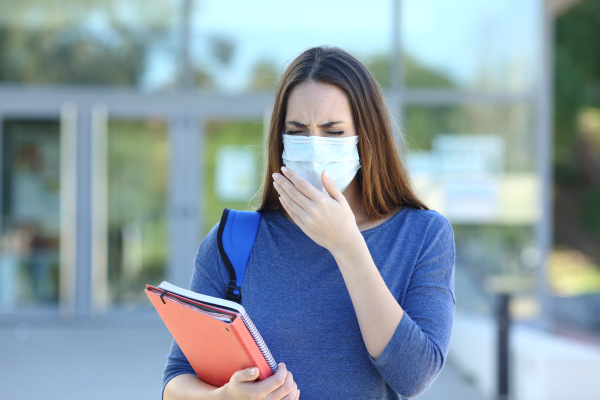 ill student with a mask coughing