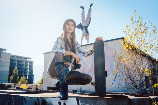 woman with skateboard and acrobat man