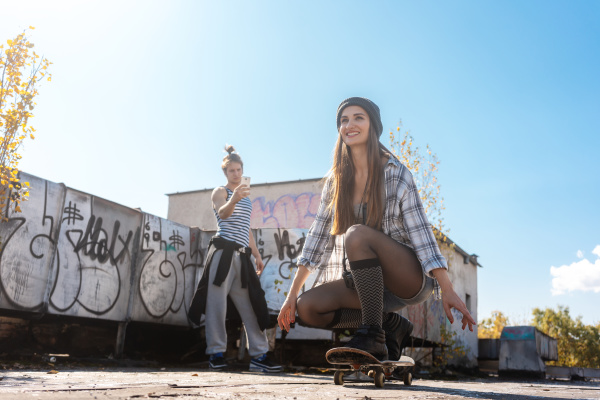 skatergirl using skateboard on abandoned building