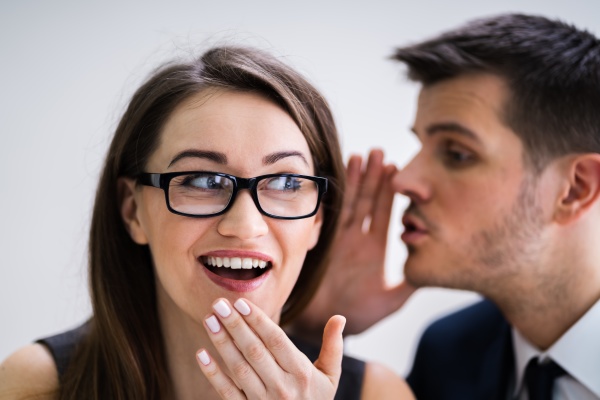 businessman whispering into female partner s
