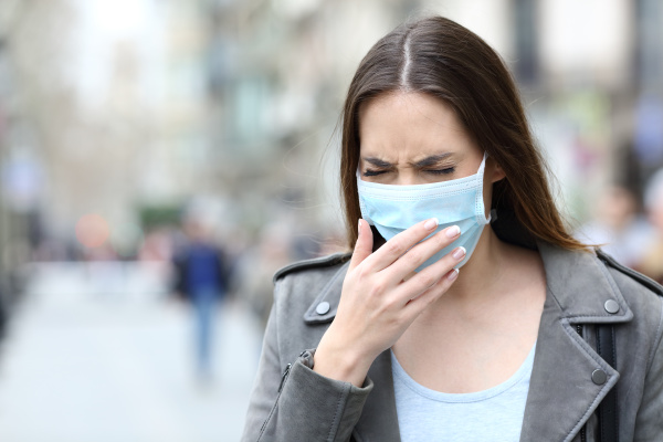sick woman with protective mask coughing