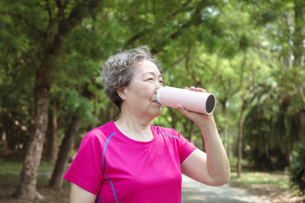 asian senior woman drinking water after