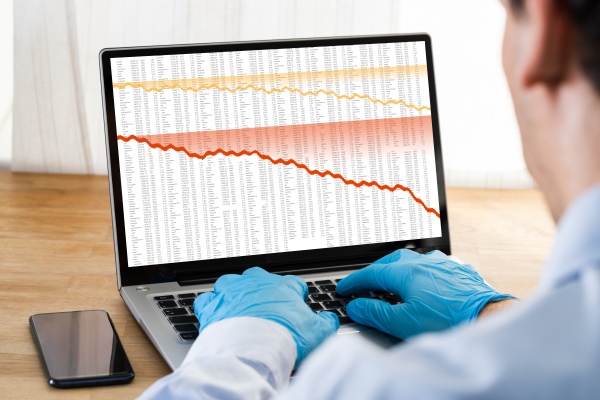 man in gloves checking stock charts