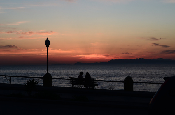 silhouette of two people sitting on
