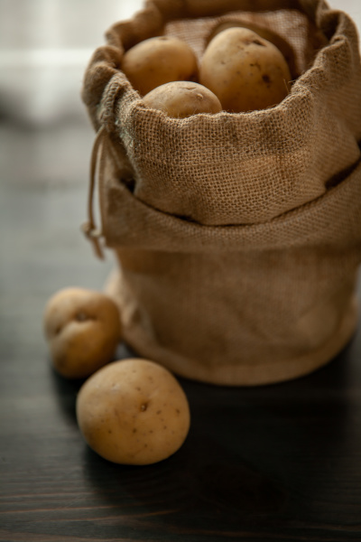 potatoes in sackcloth on rustic wooden