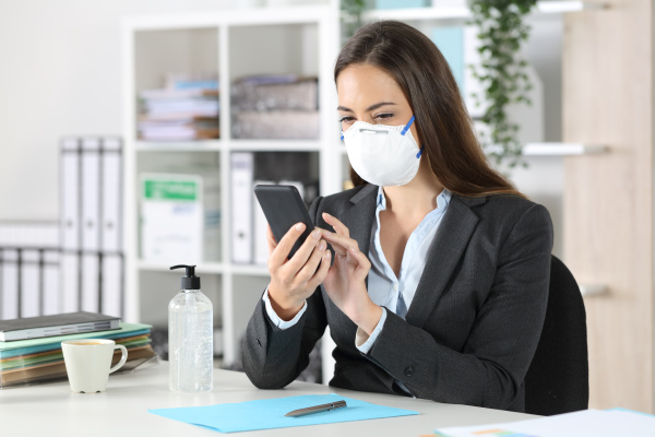 executive with protective mask using phone