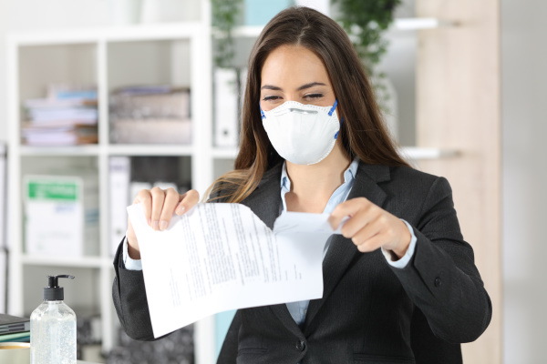 executive wearing mask ripping contract at