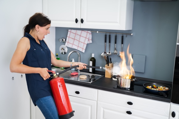 woman using fire extinguisher to stop