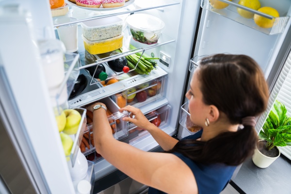 women looking for food inside fridge
