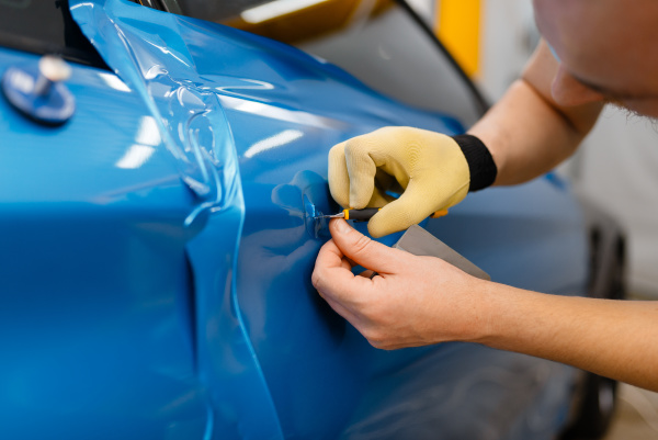 car wrapper installs protective vinyl foil