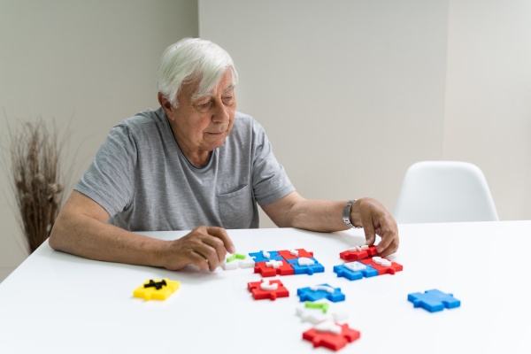 elder man playing jigsaw puzzle