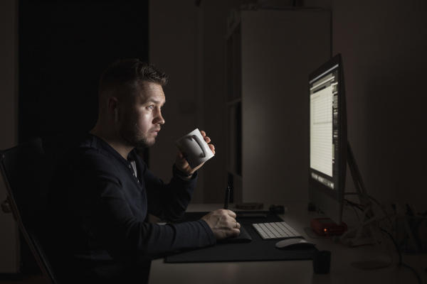 man with coffee working late at