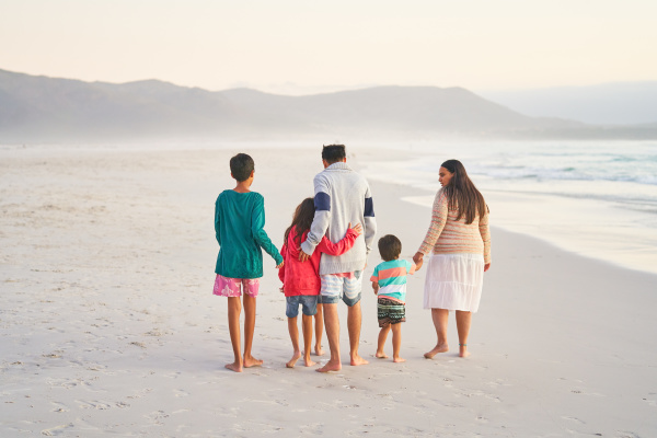 affectionate family walking on ocean beach