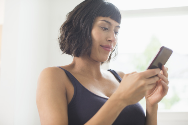woman in bra using smart phone