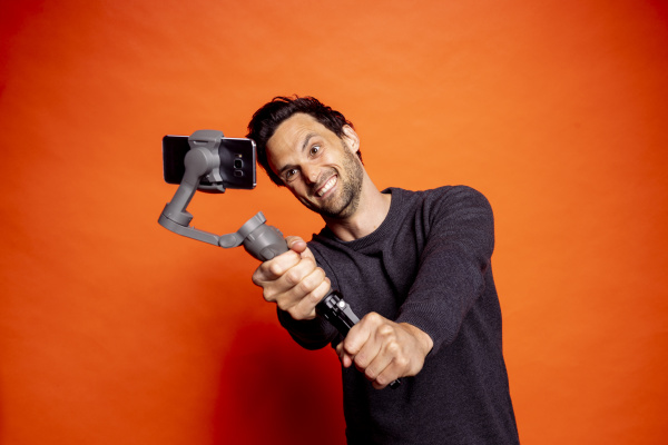 cheerful man taking selfie while holding