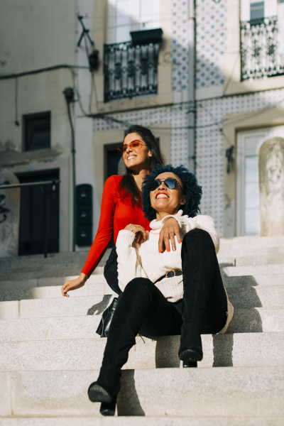 stylish female friends wearing sunglasses sitting