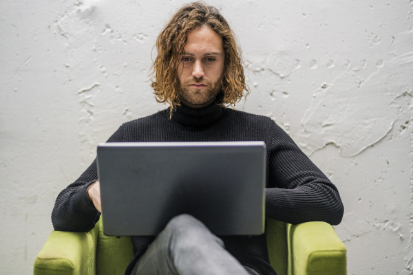 bearded young man using laptop while