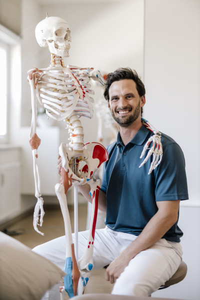 physiotherapist sitting in practice with skeleton