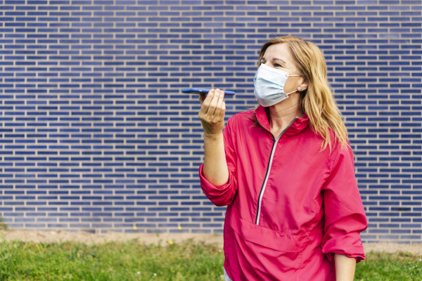woman with surgical mask using smartphone