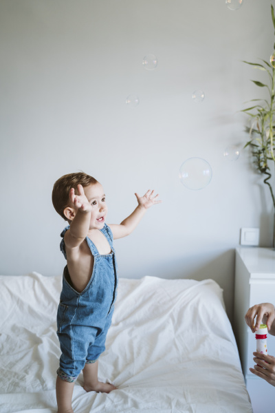 baby girl playing with bubbles at