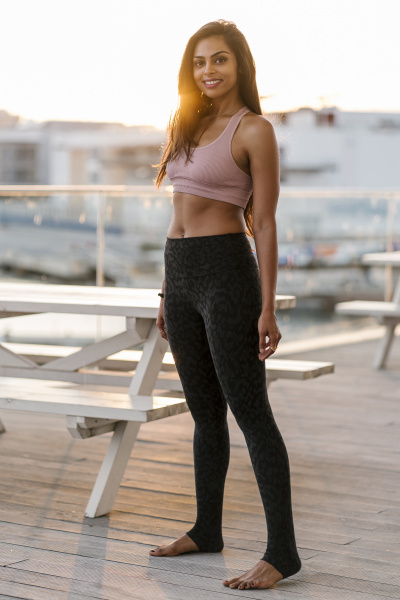 smiling female athlete standing on pier