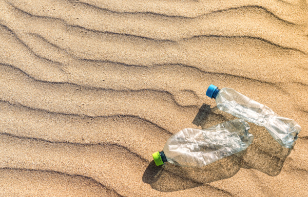 plastic bottles lying on rippled beach