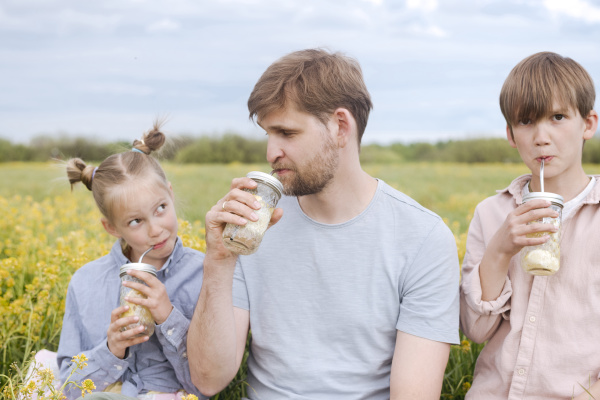 family drinking lemonade at oilseed rape