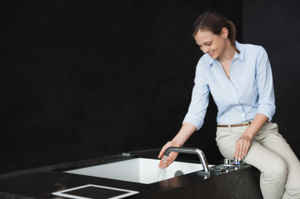 smiling mid adult woman washing hands