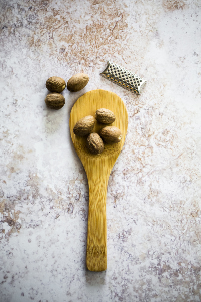 nutmeg on wooden spoon and grater