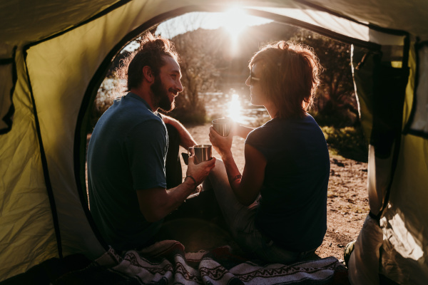 happy couple camping at lakeside