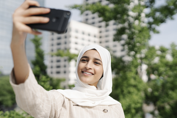 muslim teenage girl smiling while taking