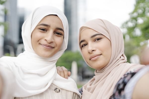 muslim sisters taking selfie in city